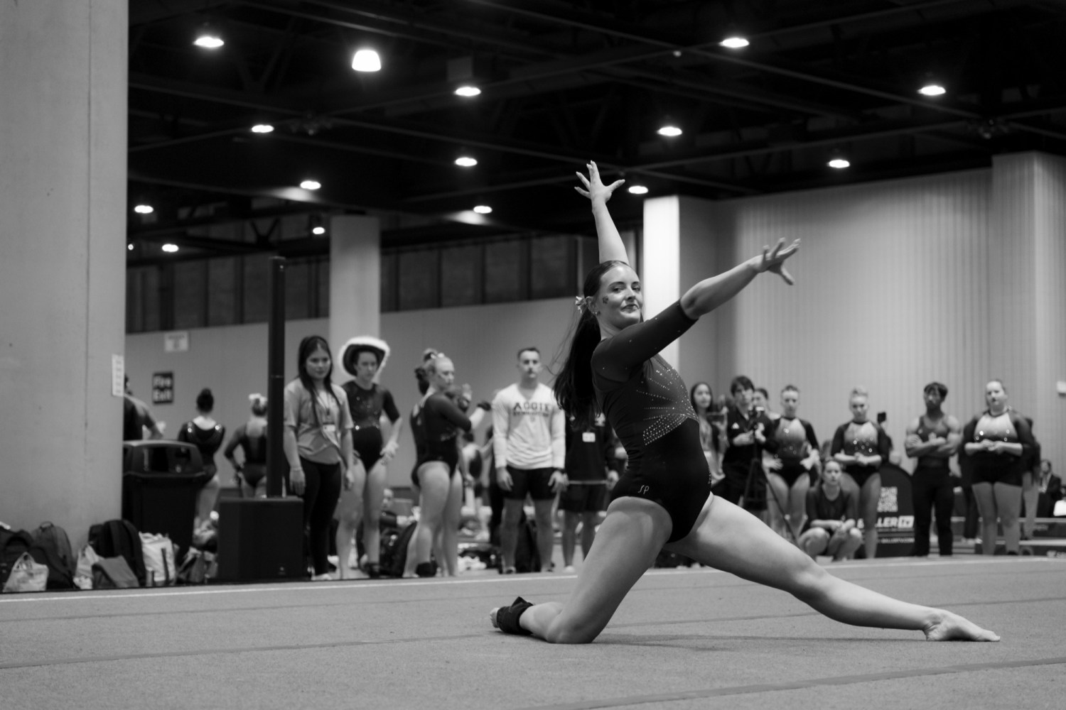 A gymnast holds a pose on floor at a UCG meet
