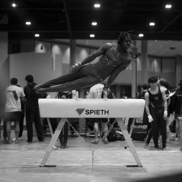 An athlete circles the pommel horse mid-routine